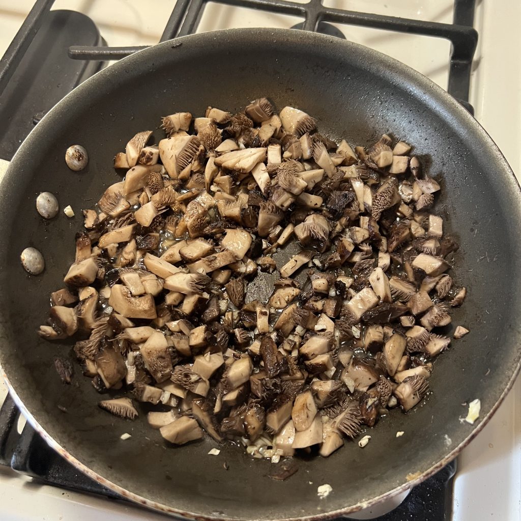 Hawks Wing mushrooms sautéing in a pan.