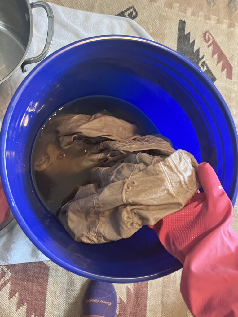 Cotton shirts in pecan dye pot.