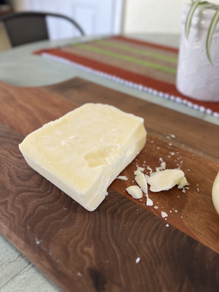 Block of rendered tallow on wood cutting board.
