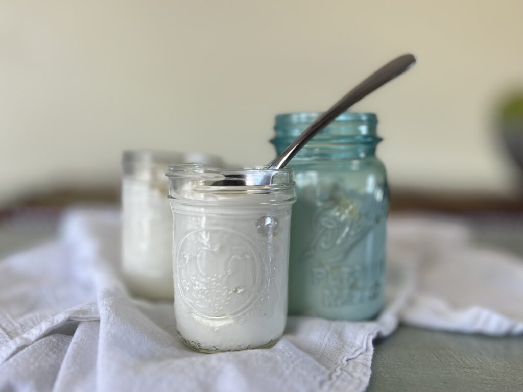 Three jars of skyr on a white flour sack towel, ready to be eaten.