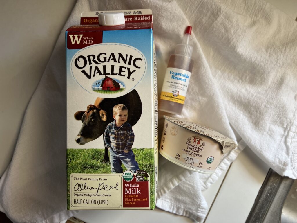 Whole milk, vegetable rennet, and Skyr laying flat on a table.