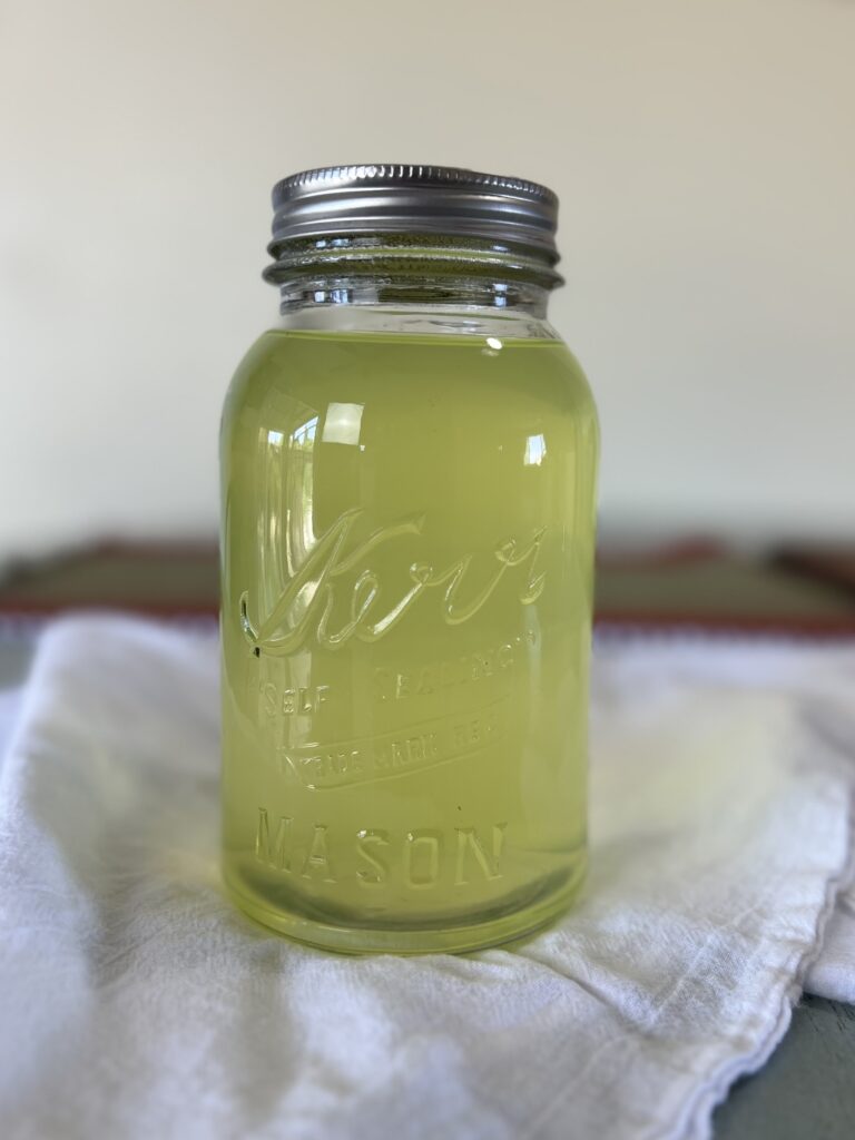 A close up of acid whey in a vintage mason jar.