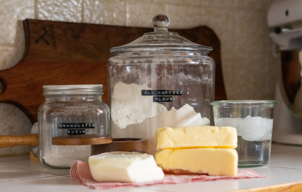 Ingredients to make a tallow and butter pie crust. All-purpose flour, sugar ice water. 