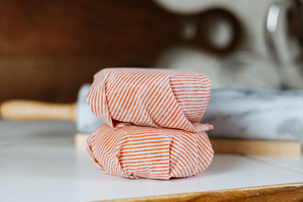 A close up of pie crust disks wrapped in beeswax wraps. 