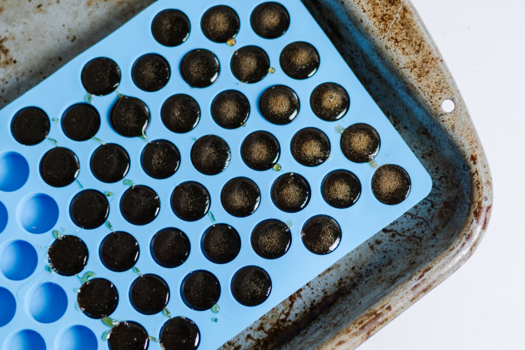 horehound candies in blue mold over a distressed cookie sheet.