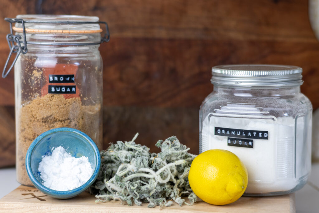 Ingredients to make horehound candy.  Brown sugar, sugar, powdered sugar, dried horehound, and lemon.