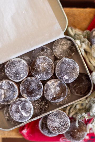 A tin of horehound candies next to dried herb and a red bandana.