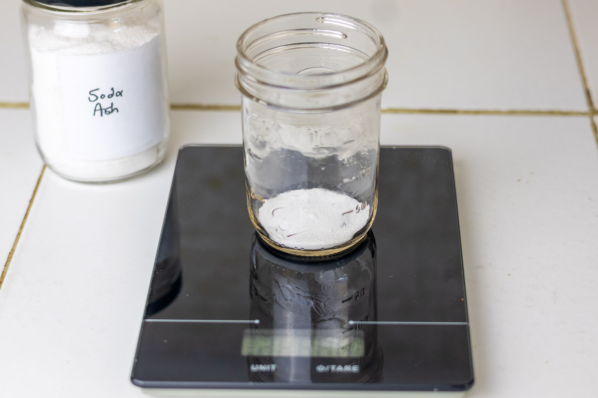Soda ash being measured out on a black food scale.
