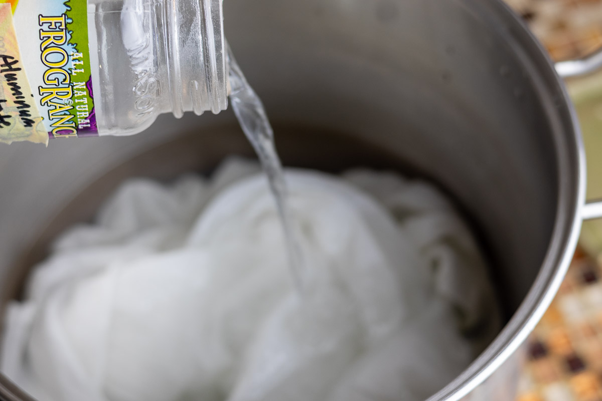 dissolved aluminum acetate being poured in pot with cotton fabric.