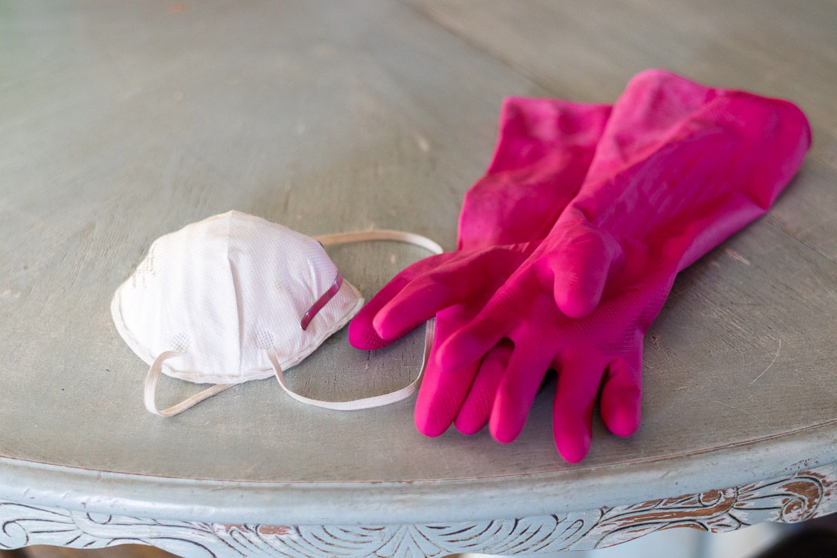 A dust mask and rubber gloves on blue table.