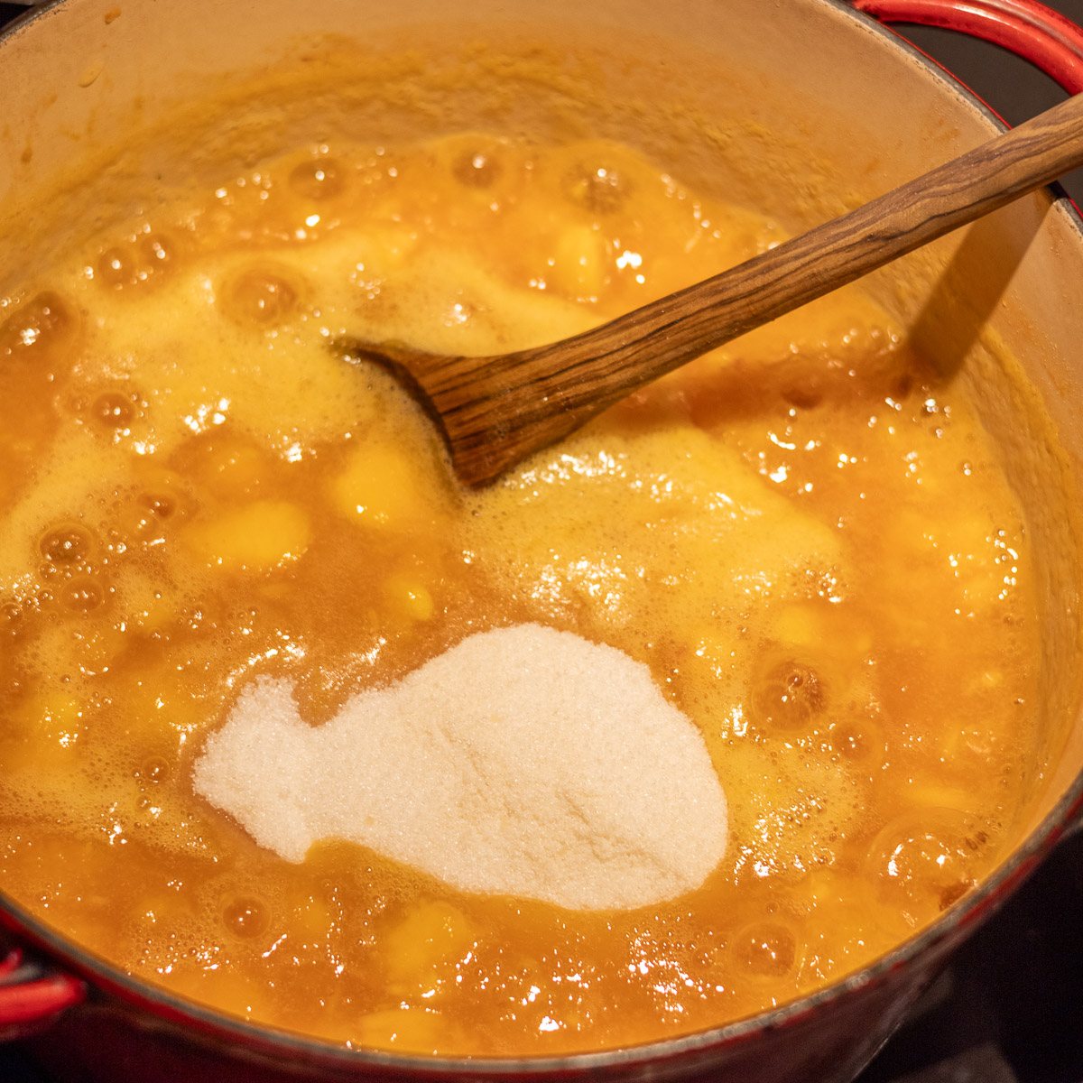 Sugar/pectin mixture in boiling mashed peaches.