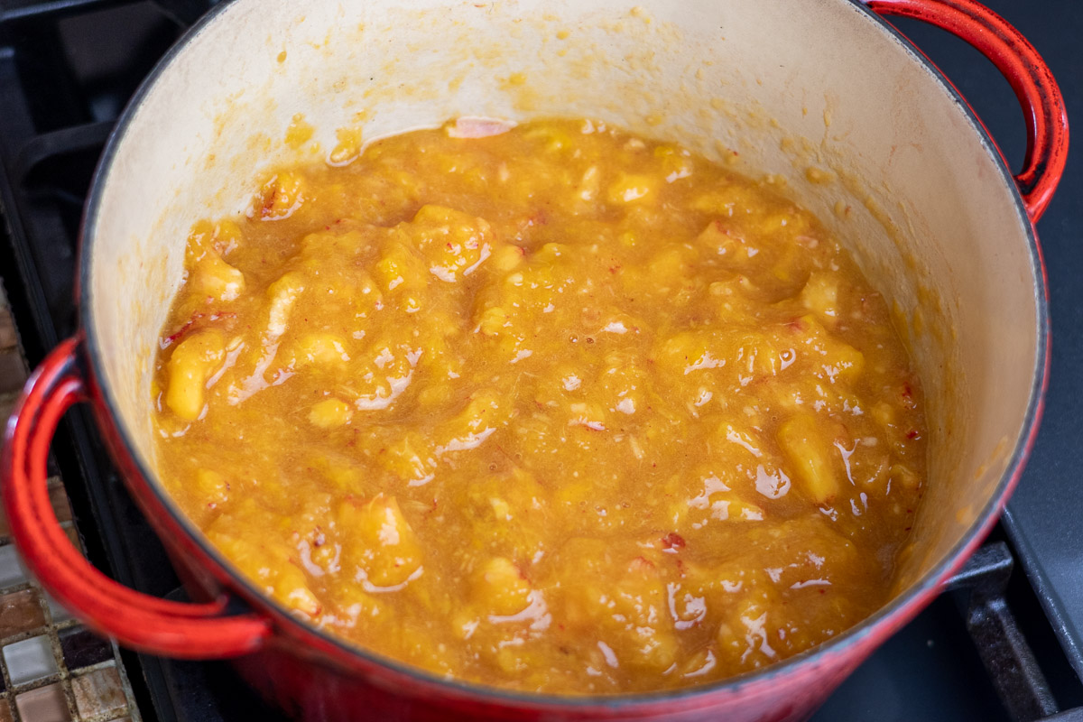 A pot with mashed peaches in it.