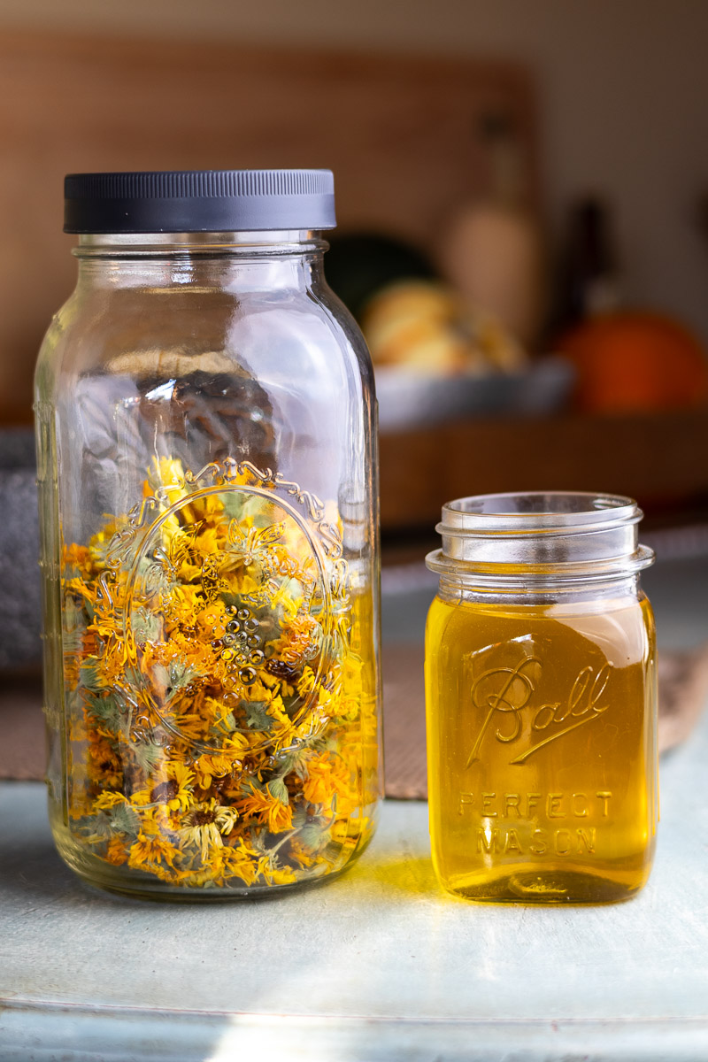 Ingredients to make calendula infused oil: a jar of dried flowers and a jar of oil.