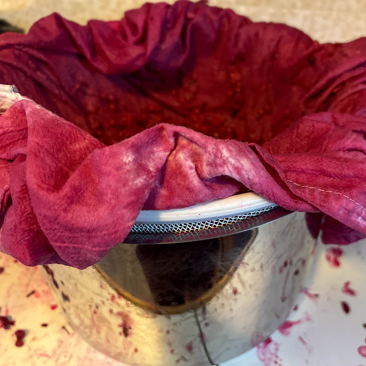 A homemade setup using flour sack towel to strain chokecherry juice.