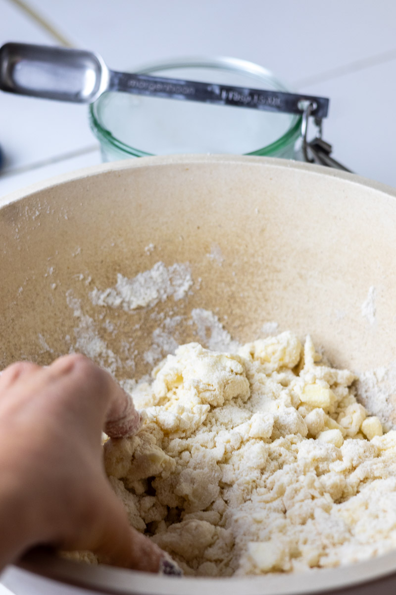 Mixing ice water into lard pie crust ingredients.