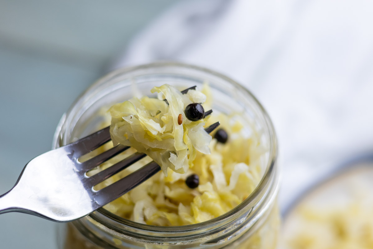 A fork showing juniper caraway sauerkraut.