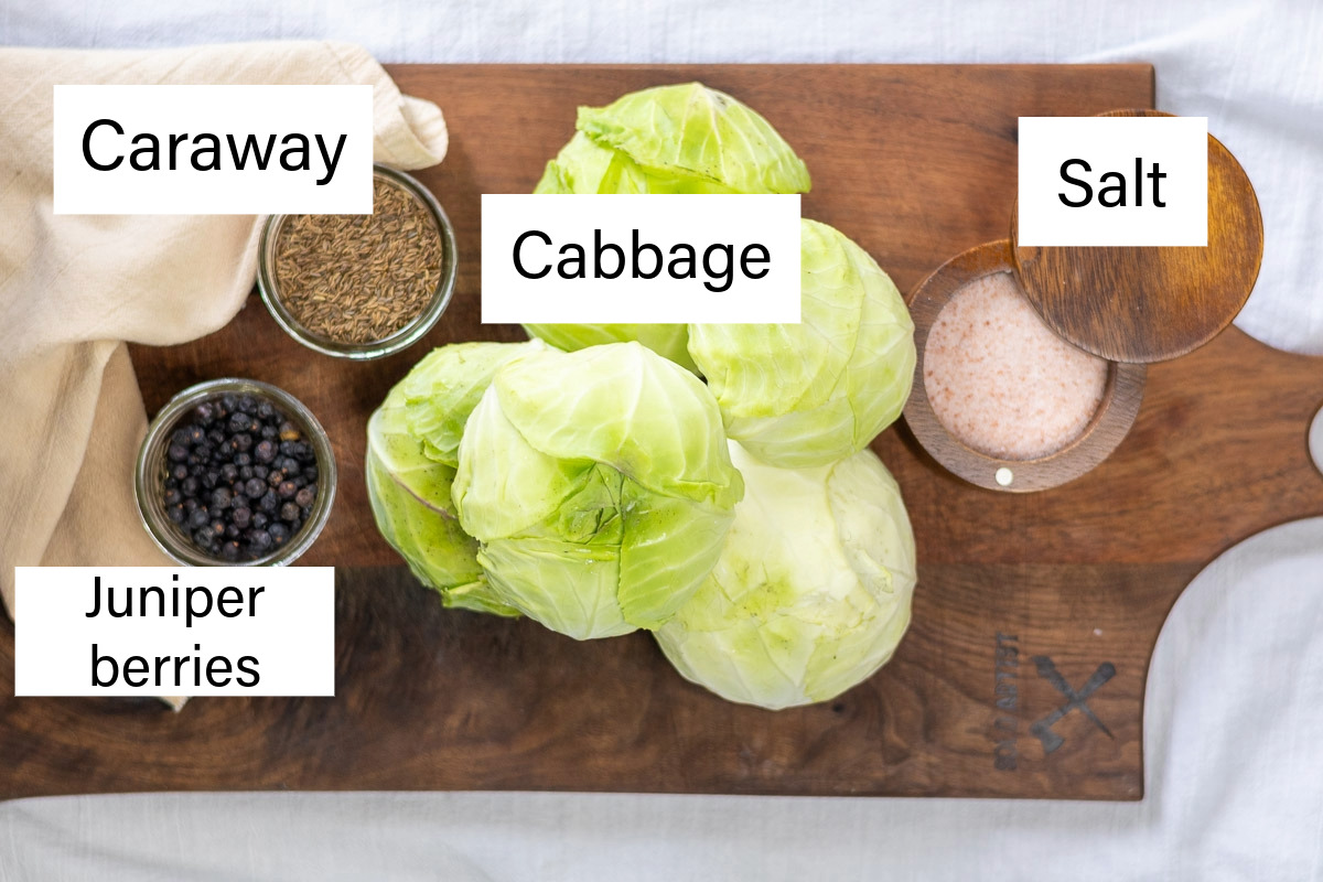 A flat lay of the ingredients to make juniper caraway sauerkraut labeled.