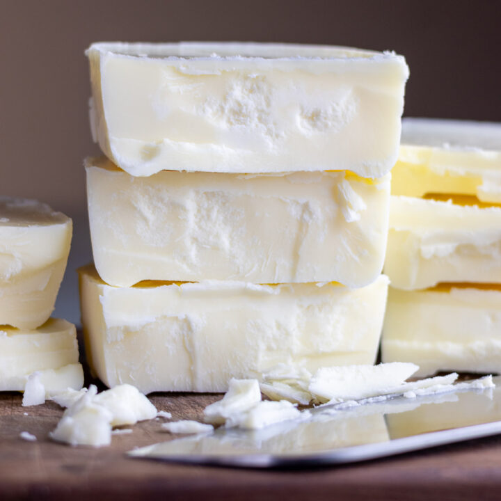 Wet rendered tallow stacked on top of each other next to a chef's knife.