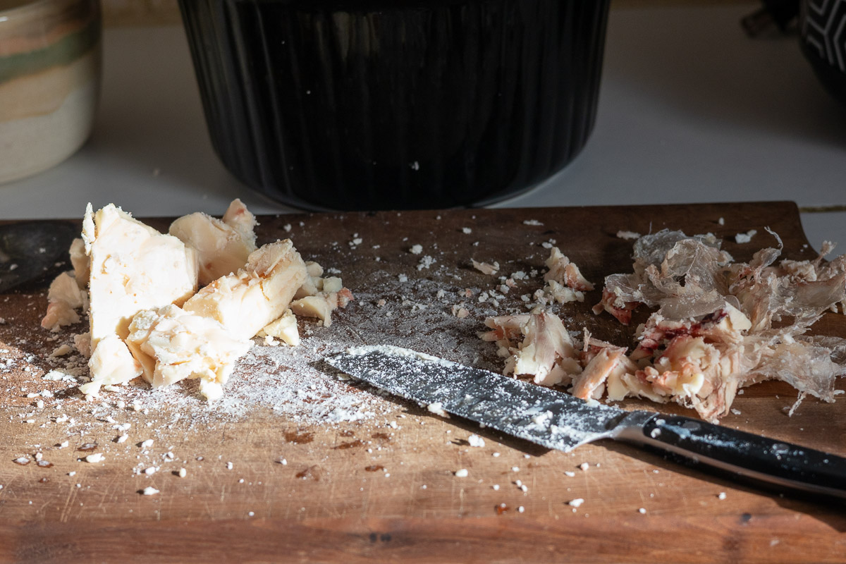 A cutting board showing the membrane and red bits cut off of suet.
