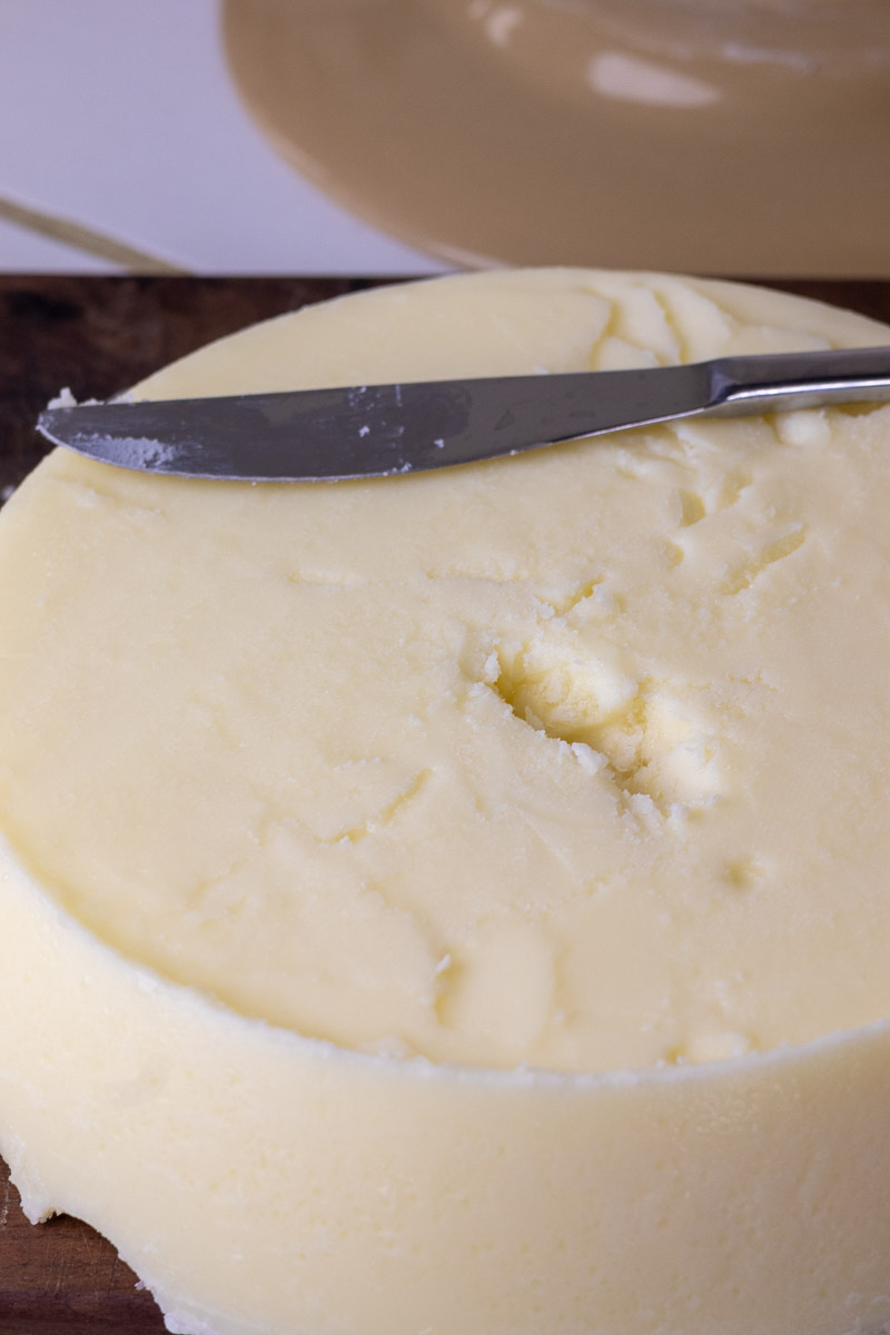 A knife demonstrating the removal of a thin brown fat layer from rendered tallow.