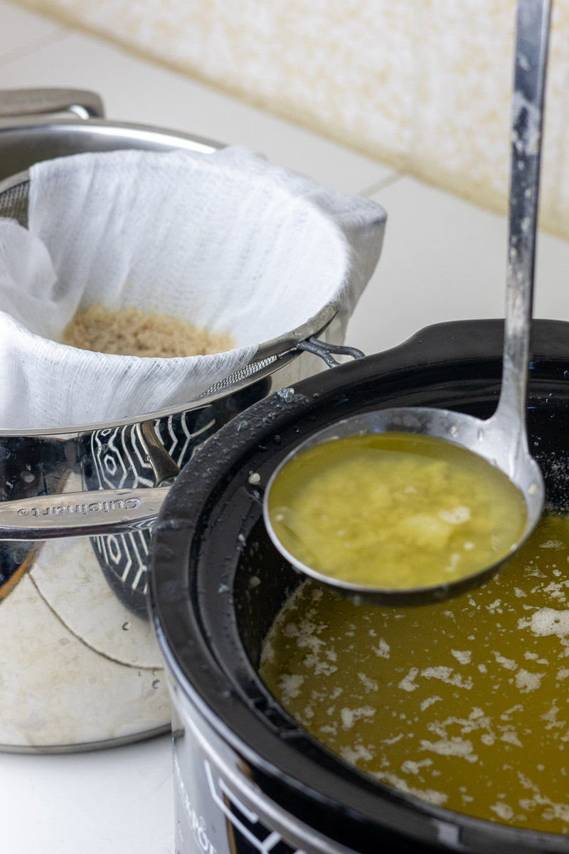 A ladle showing the straining of suet solids and liquid fat and water.