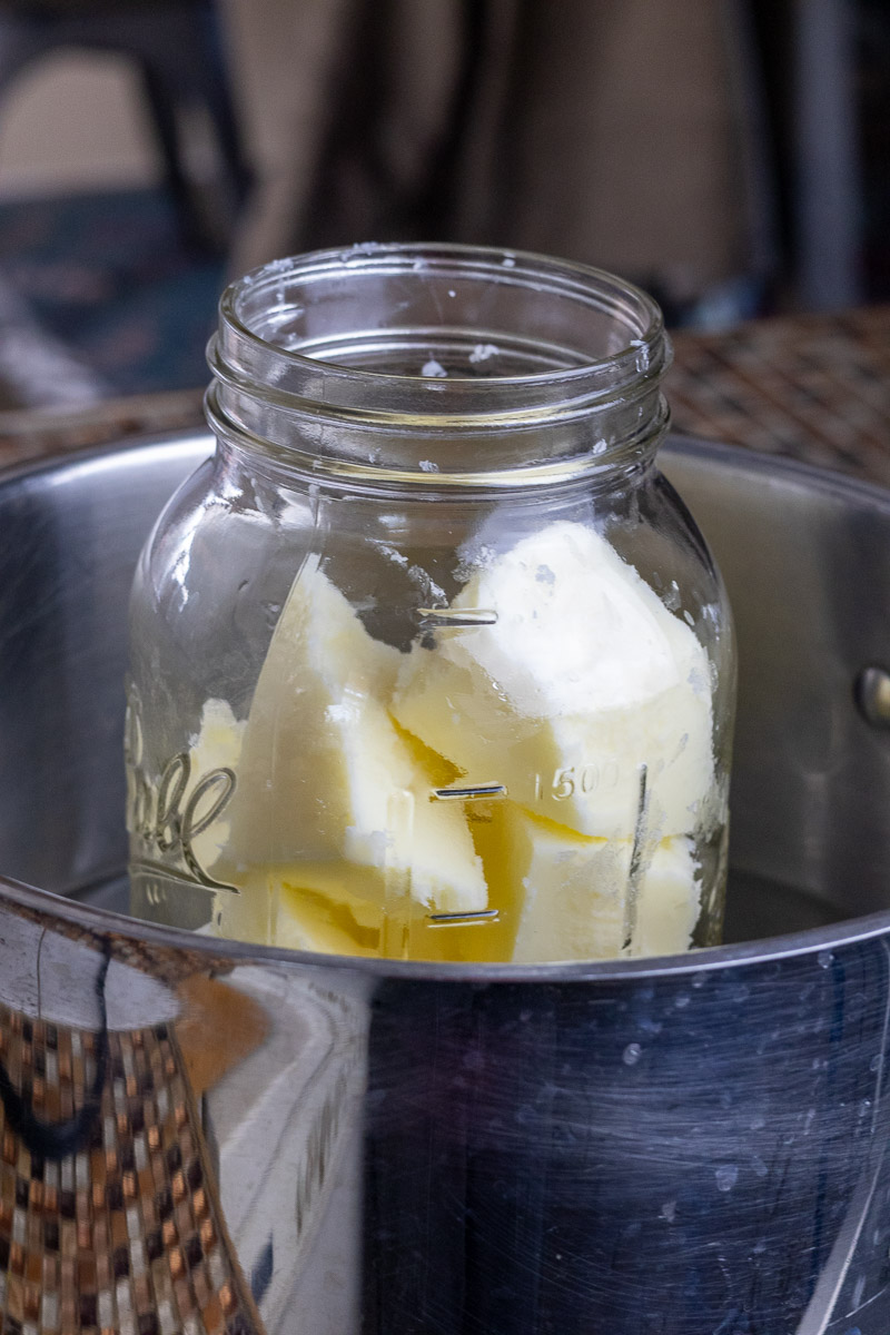 A mason jar with tallow chunks in a double boiler.