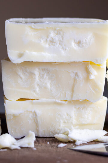 Wet rendered tallow stacked on top of each other next to a chef's knife.