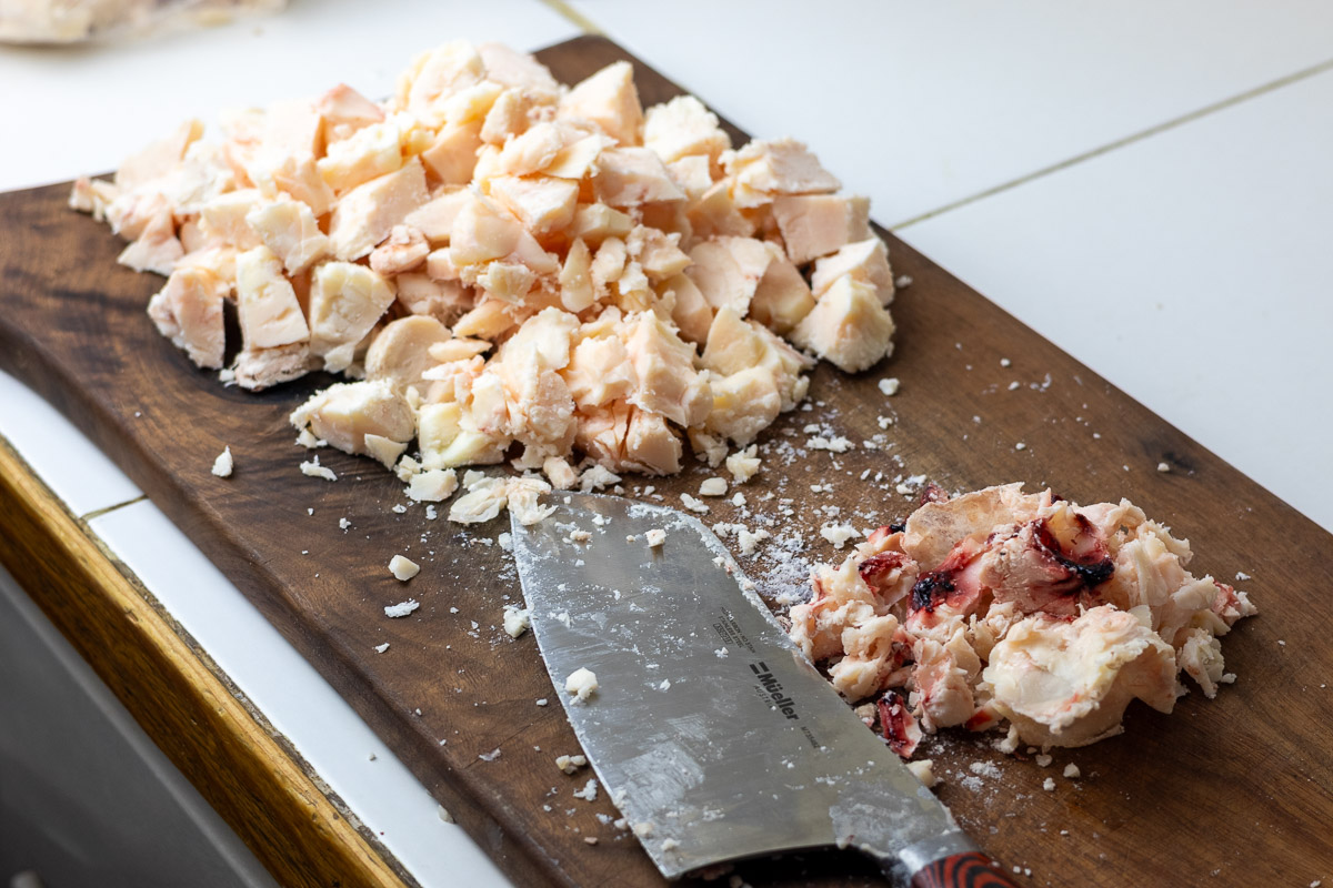 Suet getting ready to dry render into tallow. Suet is on a cutting board next to knife showing that the meaty bits and membrane being cut off.