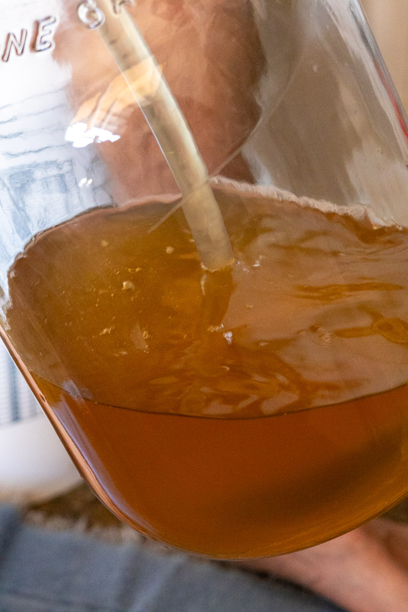 A tube showing mead being racked into a new gallon carboy.