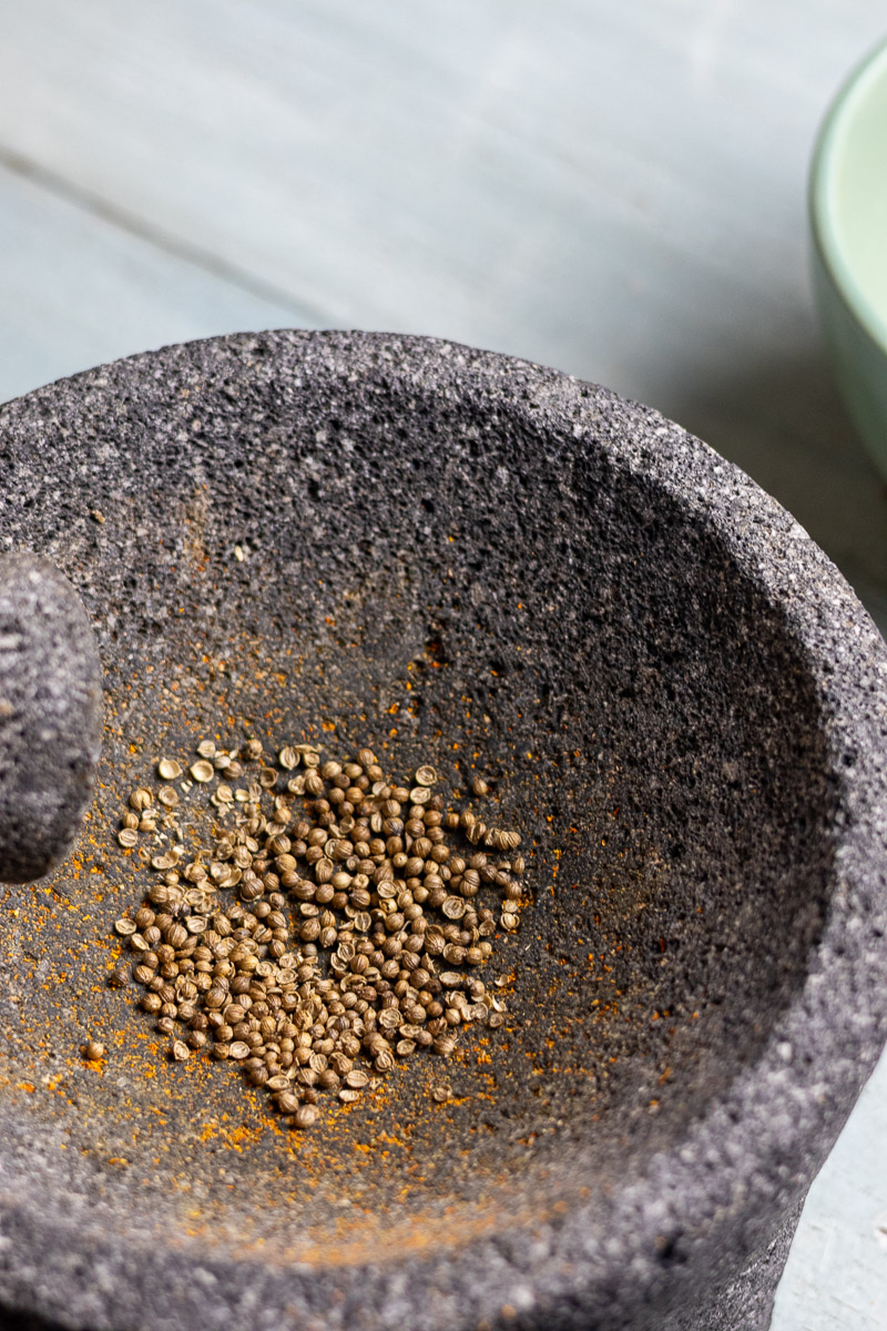 Coriander seeds in mortar and pestle.
