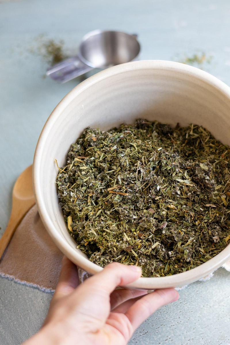 Blended ingredients for herbal tea in a ceramic bowl.